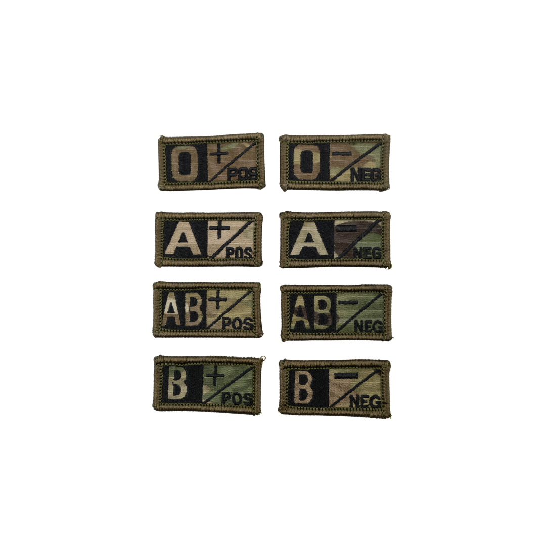 A collection of velcro patches with different blood type designs, including O+, O-, A+, A-, AB+, AB-, B+, and B-. Multicam