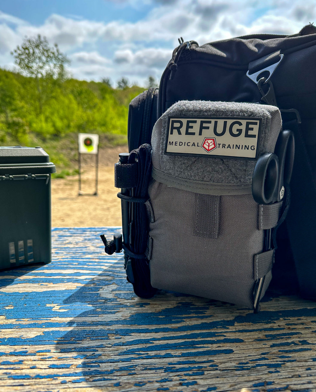 Refuge Medical BearMIN First Aid Kit - Gray Staged on a table at a shooting range