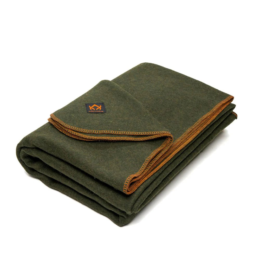 A folded dark olive green wool Arcturus blanket with orange stitching and a visible brand logo on the lower right corner.