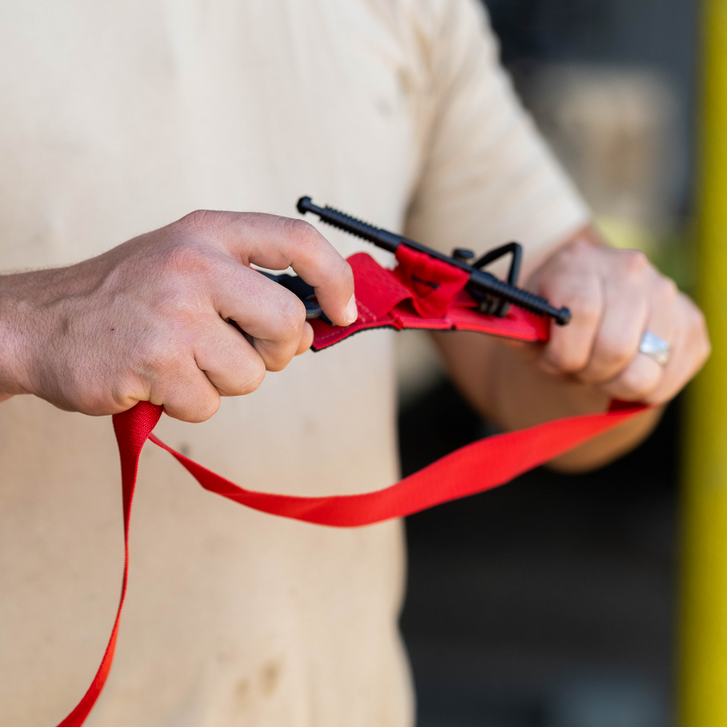 Someone holding a red SOF-T tourniquet open