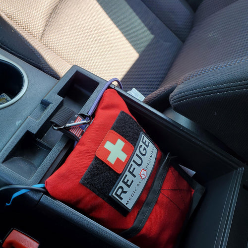 Refuge Medical Boo Boo First Aid Kit - Red inside a glove box in a vehicle 