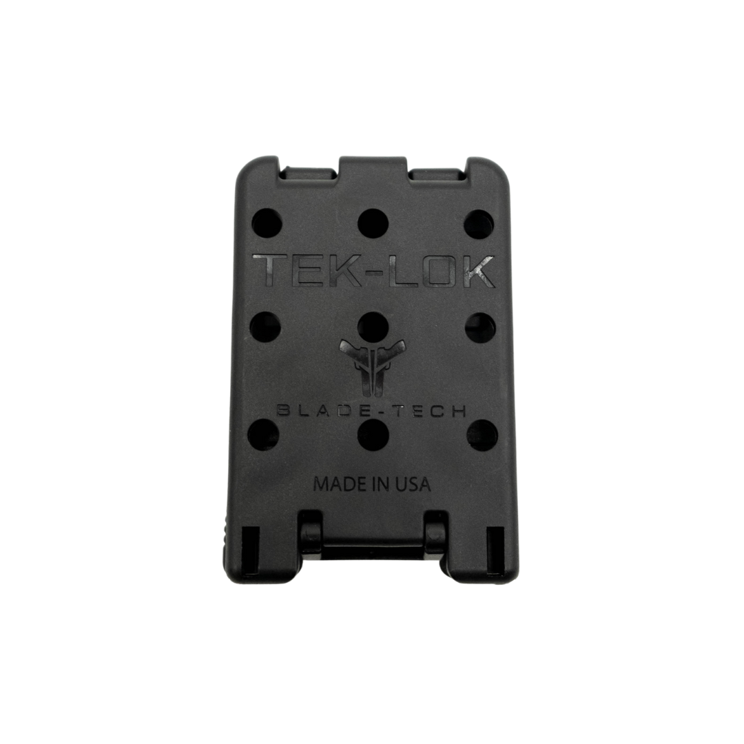 A black Blade-Tech TEK-LOK belt clip with multiple mounting holes, on a white background.